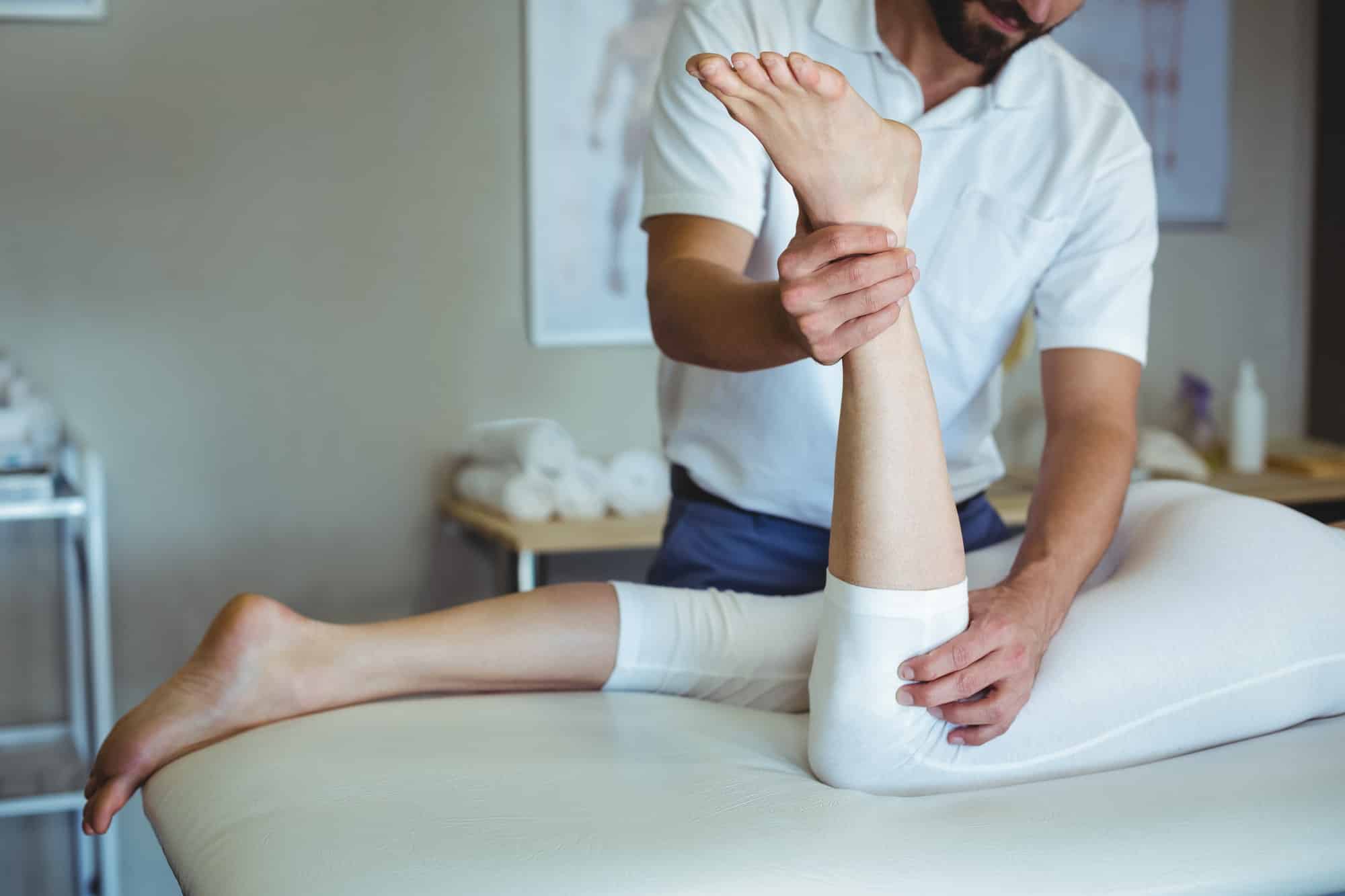 Physiotherapist giving leg massage to a woman